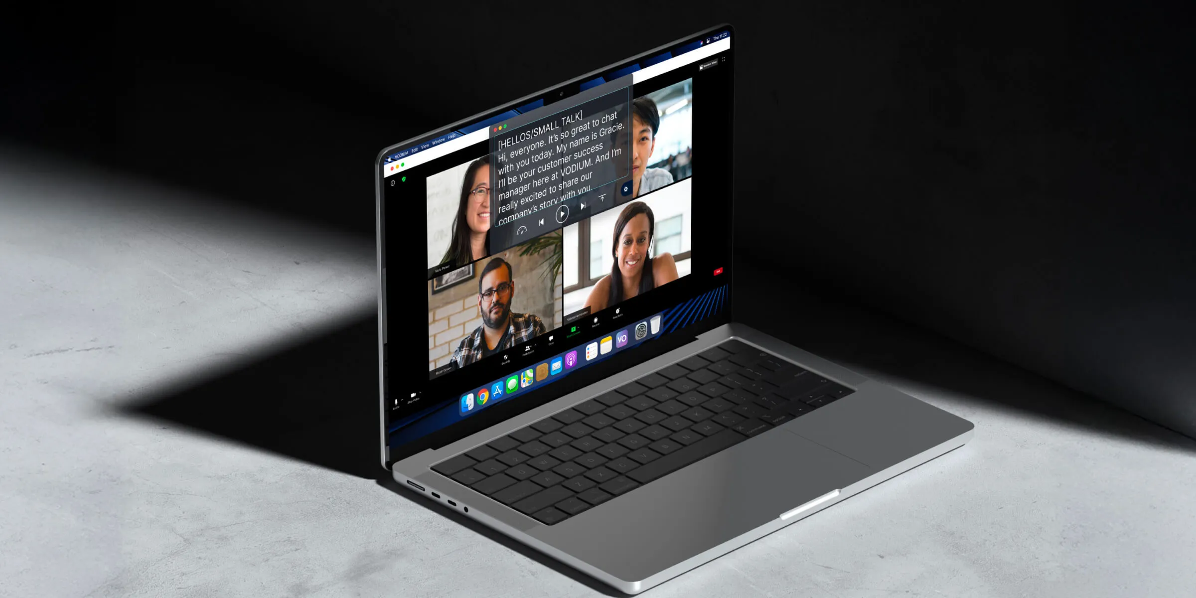 A sleek laptop sits open on a dark surface, displaying a desktop application with a teleprompter running called Vodium, alongside a video conference with four participants.